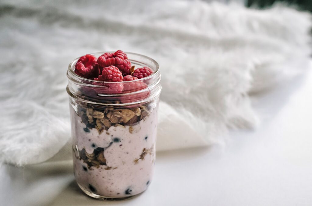 Queen Garnet Breakfast Parfait in a glass, with fresh berries on top