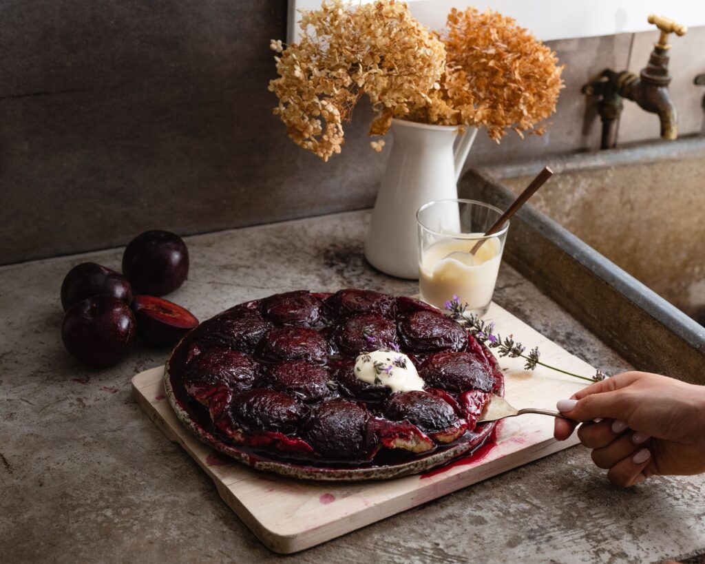 A dish of Queen Garnet Plum Tarte Tatin with a dollop of cream on top